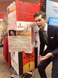 Man in suit looking confused while standing next to an interactive booth.