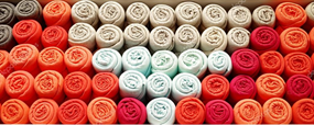 Colorful rolled up t-shirts arranged in a geometric pattern.