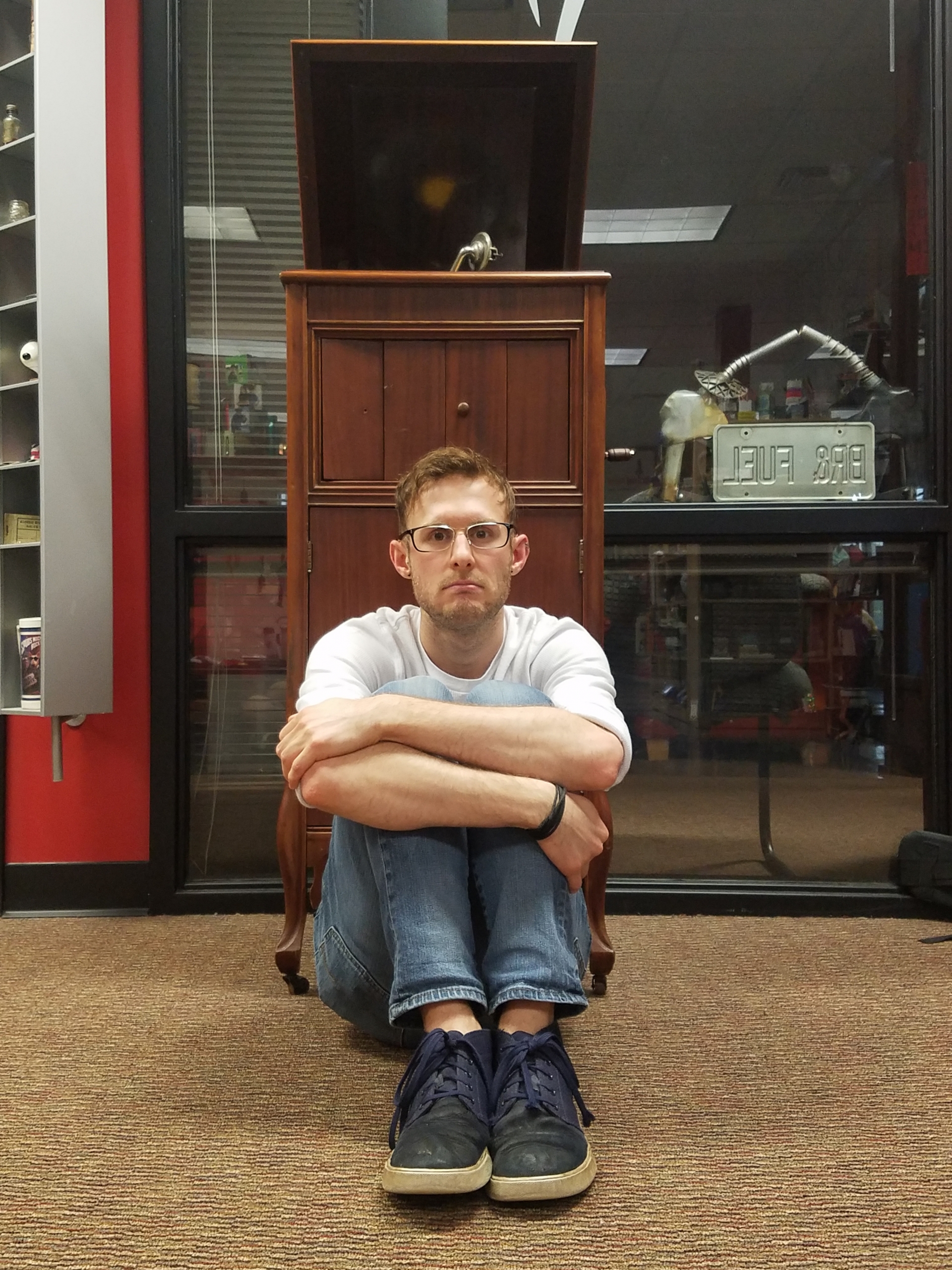 BrandFuel employee Blake Waller sitting on the floor with his arms crossed over his knees